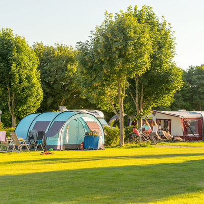 Bild vergrößern: Campingplatz mit mehreren Zelten und Wohnwagen und viel grnem Rasen