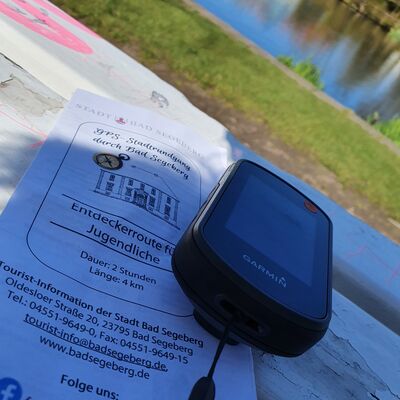 Bild vergrößern: Ein GPS-Gert liegt zusammen mit einem Infromationsblatt auf einer Parkbank