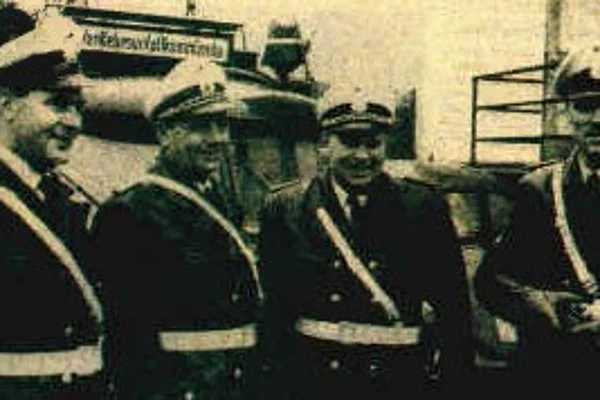 Vier Polizisten in Uniform mit Schärpen stehen nebeneinander im Freien