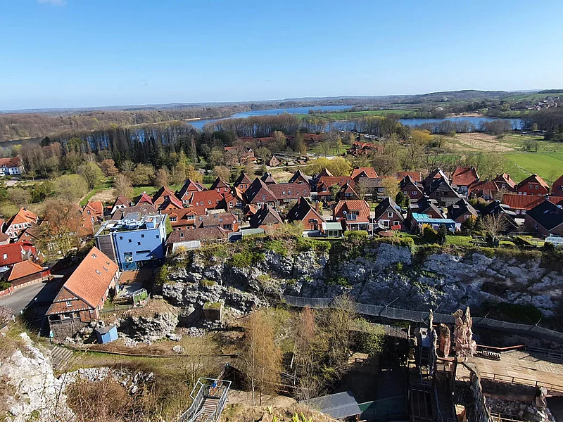 Blick vom Kalkberg auf die Lübecker Straße mit roten Ziegeldächern, Felsen im Vordergrund und Seen im Hintergrund