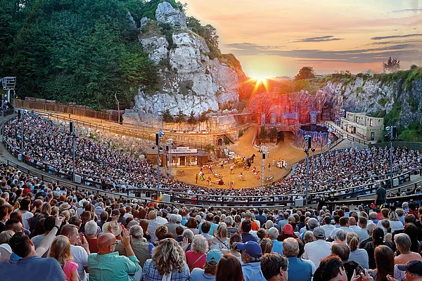 Großes Freilichttheater bei den Karl-May-Spielen Bad Segebergs mit vollbesetztem Zuschauerraum und Schauspielern auf der Bühne bei Sonnenuntergang