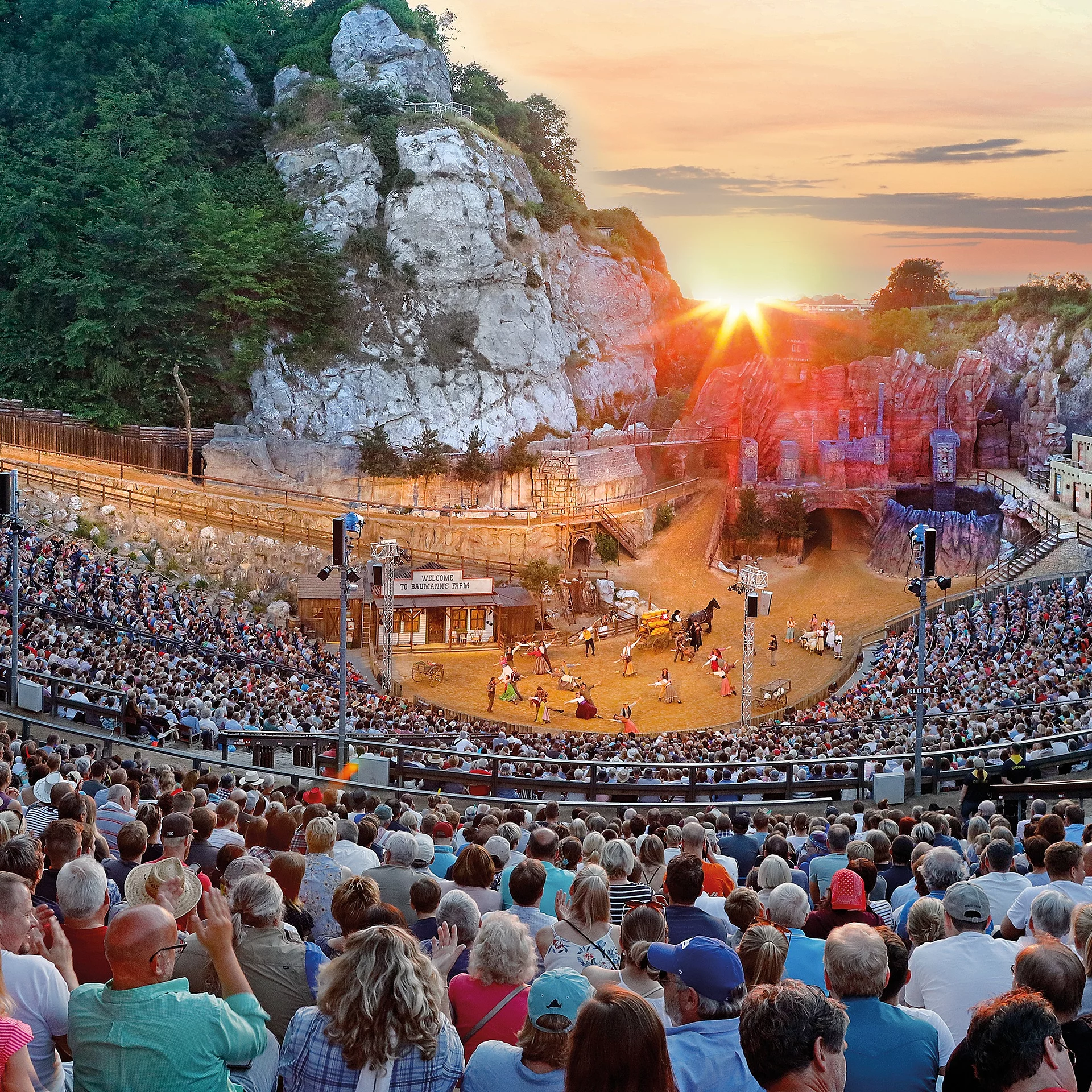 Großes Freilichttheater bei den Karl-May-Spielen Bad Segebergs mit vollbesetztem Zuschauerraum und Schauspielern auf der Bühne bei Sonnenuntergang
