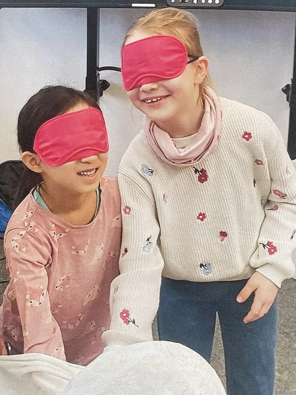 zwei Kinder mit Augenbiden ertasten ein Kustobjekt