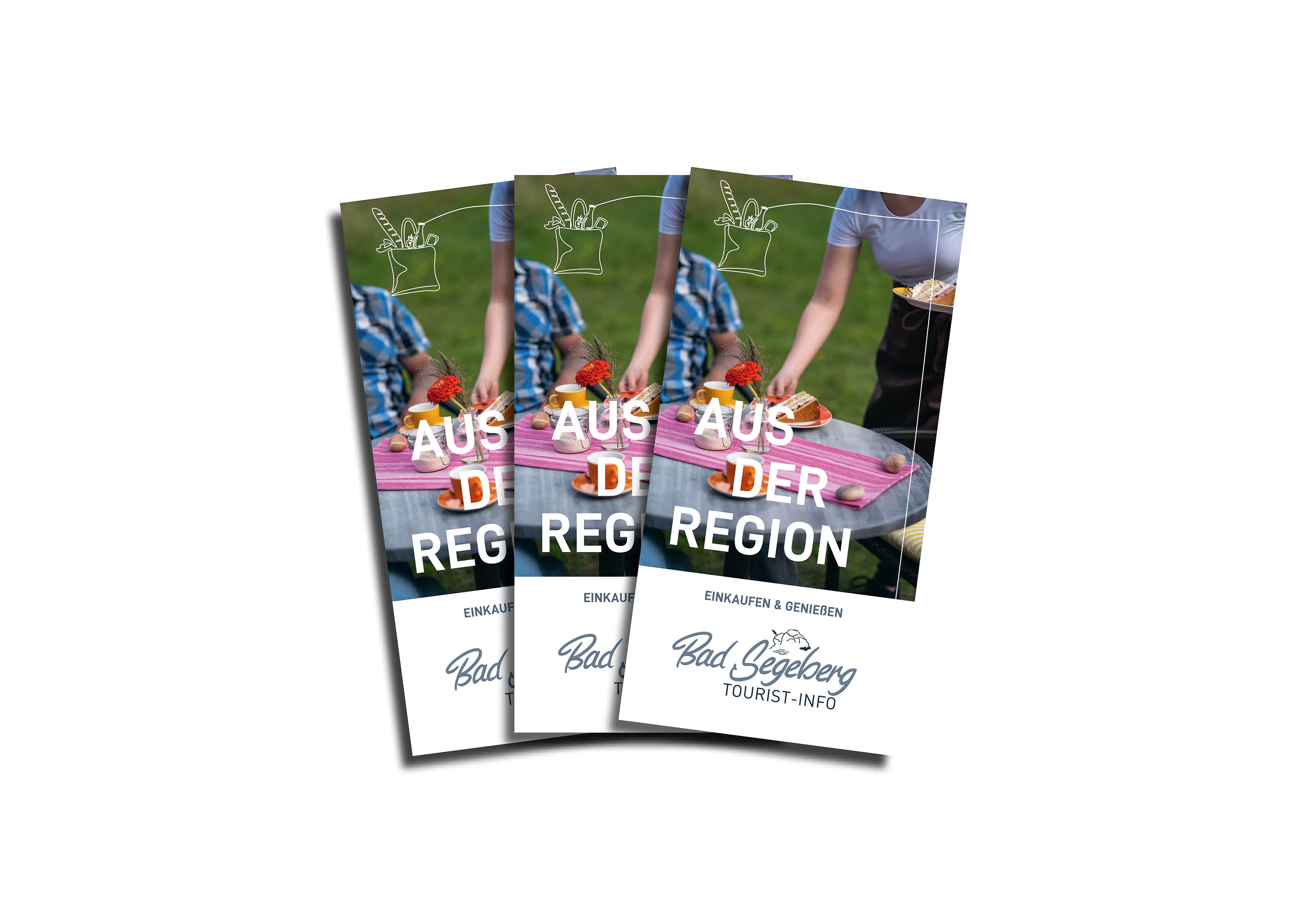 Drei Flyer mit der Aufschrift 'Aus der Region' und 'Bad Segeberg Tourist-Info' vor einem Hintergrund mit gedecktem Tisch und Personen.