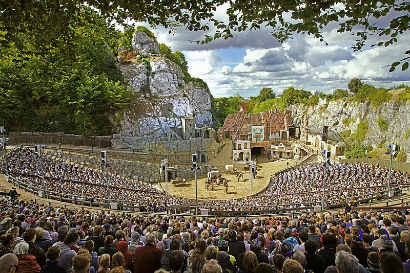 Freilichtbühne der Karl-May-Spiele Bad Segeberg mit Zuschauern und Westernkulisse vor Felsen unter bewölktem Himmel