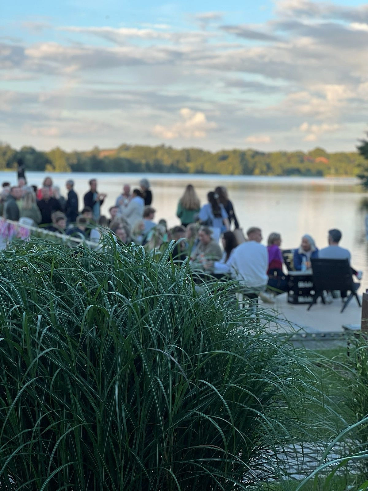 Menschen in der Abenddämmerung bei der Goldmarie am See