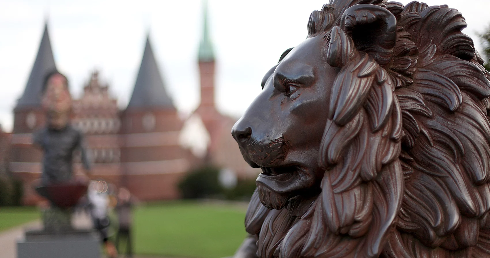 Löweskulptur im Vordergrund, im Hintergrund das Holstentor