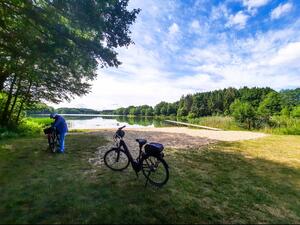 Bild vergrößern: Badestelle am Blunker See. Ein Fahrrad steht vor dem Strandabschnitt.