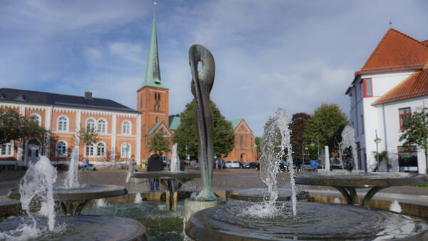 Bild vergrößern: Brunnen auf dem Marktplatz von Bad Segeberg, im Hintergrund die imposante Marienkirche