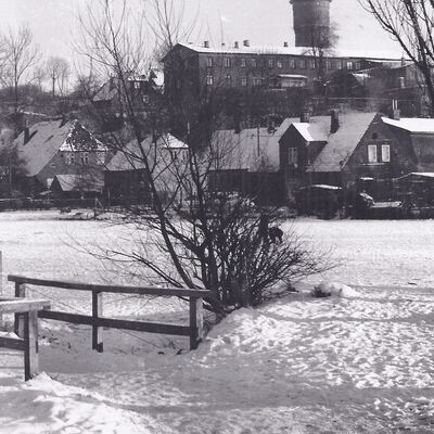 Bild vergrößern: Schwarz-weiß Foto von 1938. Im Vordergrund liget der schneebedeckte Kleine Segeberger See, im Hintergrund ist der Wasserturm zu sehen