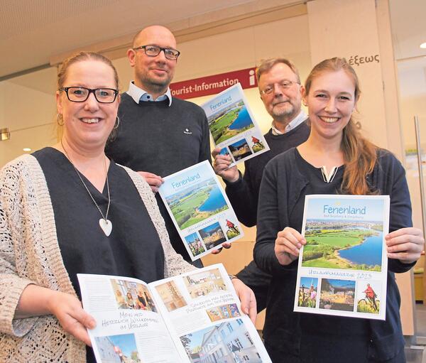 Bild vergrößern: Vier Personen halten das neue Urlaubsmagazin in den Händen.