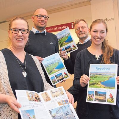 Vier Personen halten das neue Urlaubsmagazin in den Hnden.