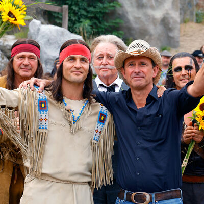 Bild vergrößern: Winnetou-Darsteller Alexander Klaws und Regisseur Nicolas Knig stehen umarmt auf der Bhne und sehen mit Dank im Blick ins Publikum